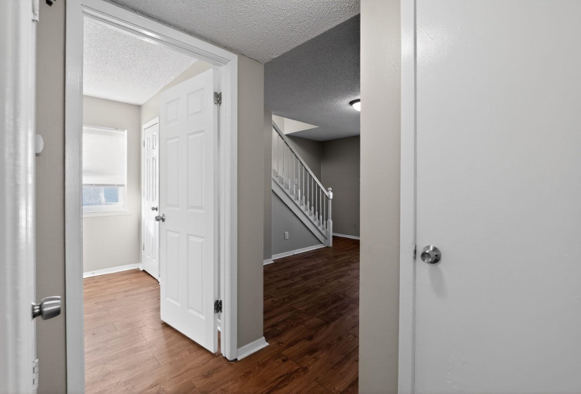 Hall with stairway, dark wood-style floors, and a textured ceiling