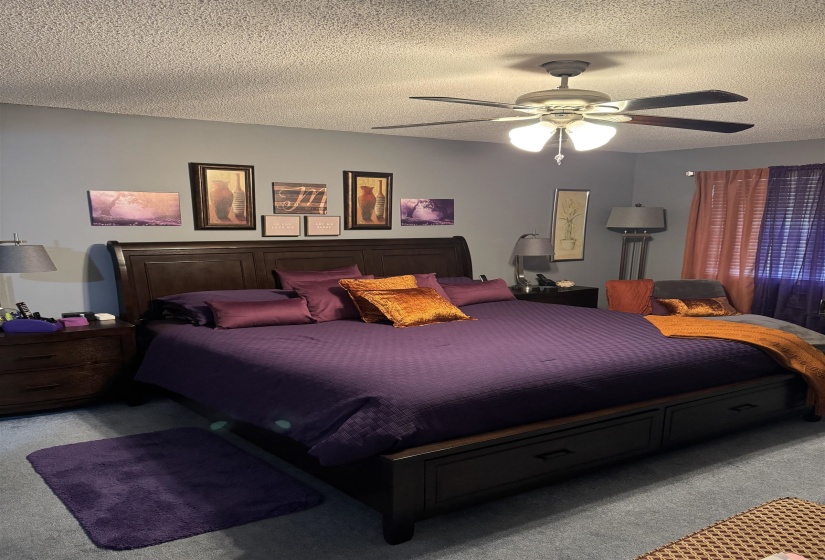 Bedroom featuring carpet floors, a textured ceiling, and ceiling fan