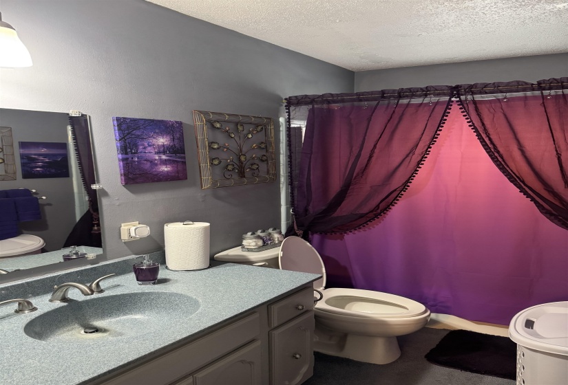 Full bathroom with vanity and a textured ceiling