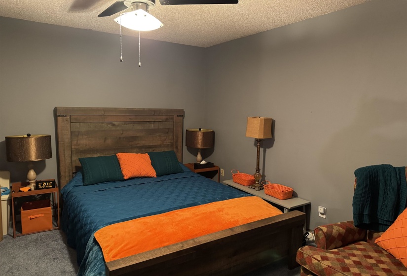 Bedroom with carpet flooring, a textured ceiling, and a ceiling fan