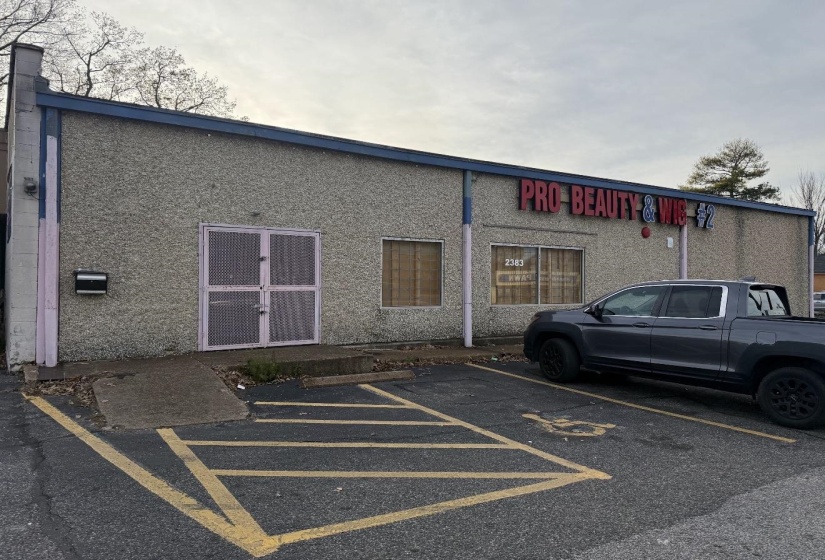 View of building exterior with uncovered parking