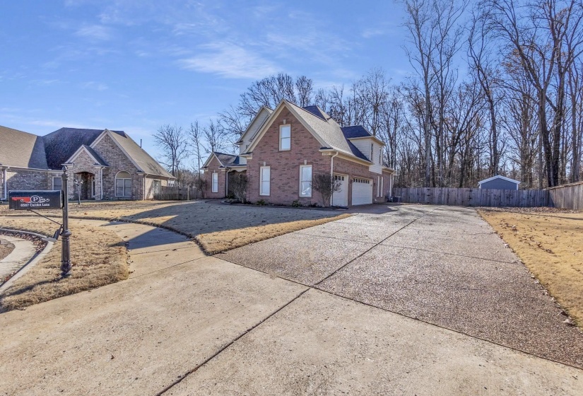 View of side of home featuring concrete driveway, a garage, and brick siding