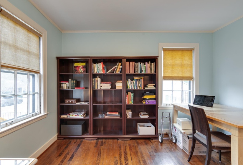 Office area featuring dark wood-style floors and ornamental molding
