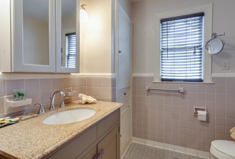 Bathroom with vanity, plenty of natural light, and a wainscoted wall