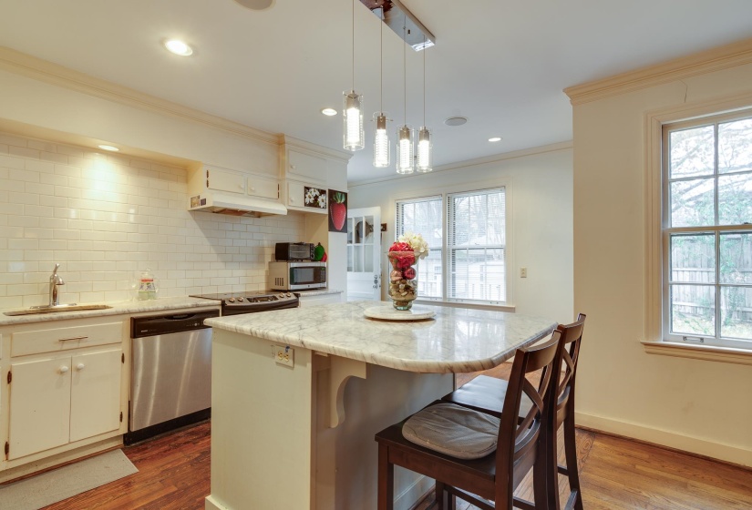Kitchen featuring a center island, a breakfast bar area, tasteful backsplash, hanging light fixtures, and stainless steel appliances