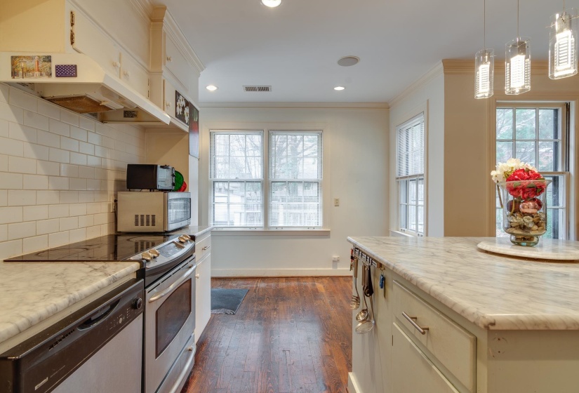 Kitchen featuring appliances with stainless steel finishes, backsplash, dark wood-style floors, decorative light fixtures, and recessed lighting