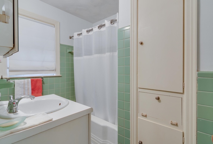 Bathroom featuring tile walls, vanity, shower / bath combo, and a wainscoted wall