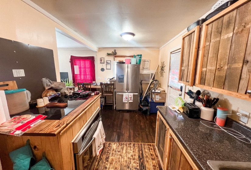 Kitchen featuring stainless steel appliances, dark wood-style floors, and wood cabinetry.
