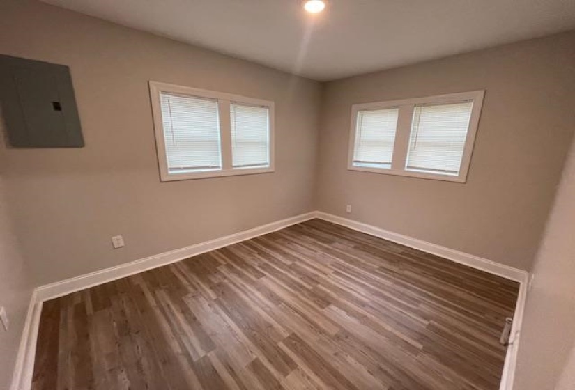 Unfurnished room featuring electric panel and wood finished floors