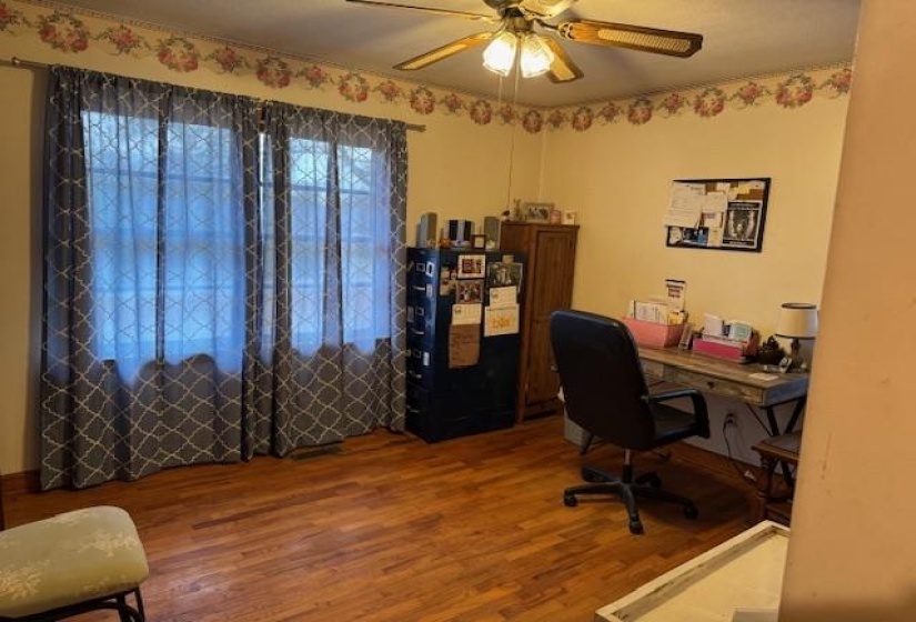 Office area with wood finished floors and ceiling fan