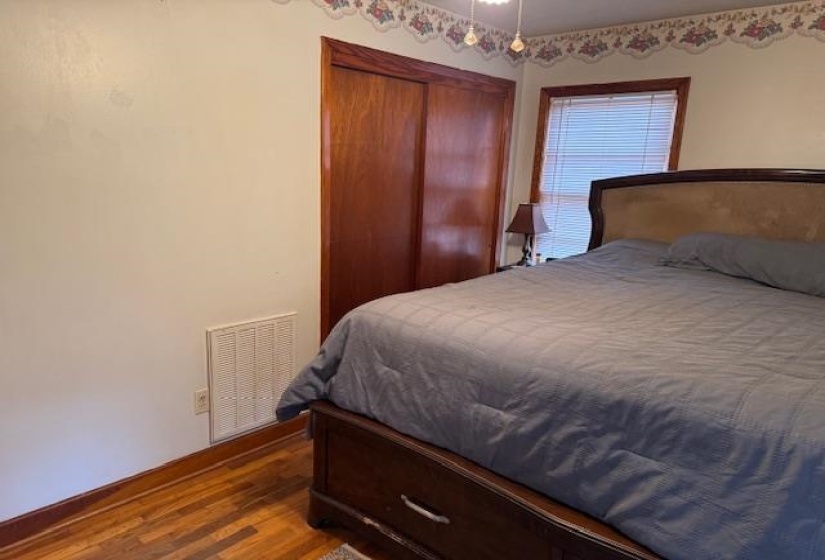Bedroom featuring dark wood-style flooring and a closet