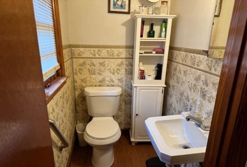 Half bath featuring toilet and wainscoting