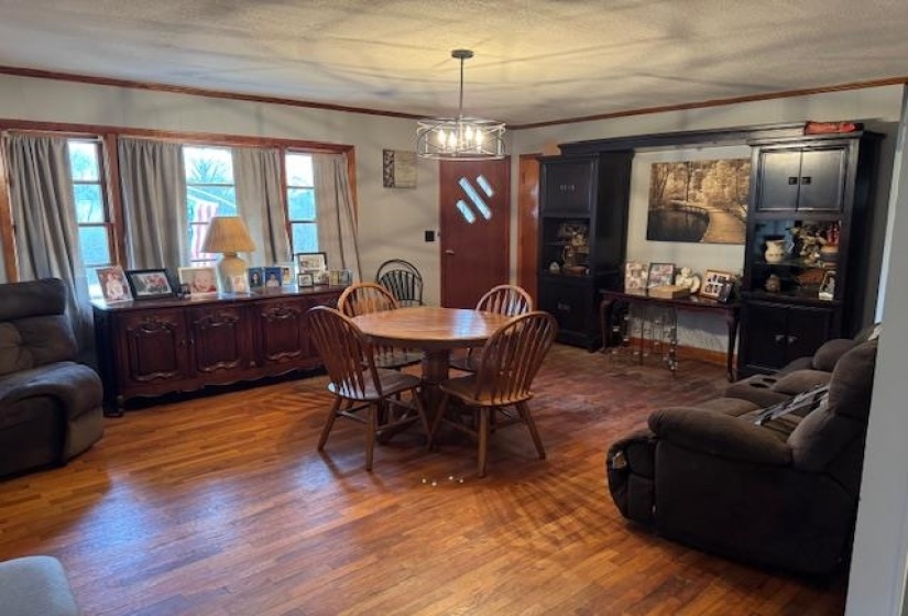 Dining space with ornamental molding, wood finished floors, and a chandelier