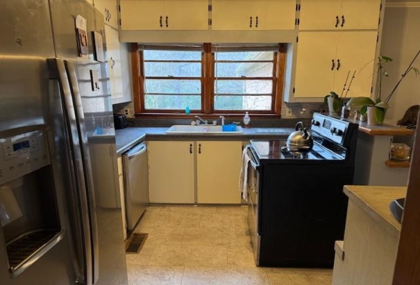 Kitchen with appliances with stainless steel finishes and a sink