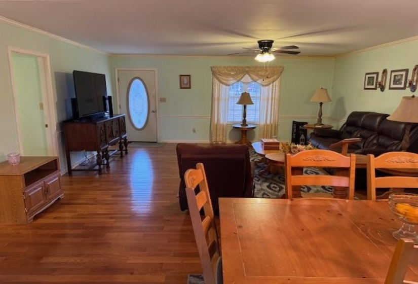 Dining room featuring ornamental molding, dark wood-type flooring, and ceiling fan