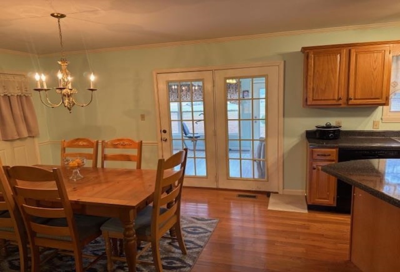 Dining area featuring a chandelier, light wood-style floors, and ornamental molding