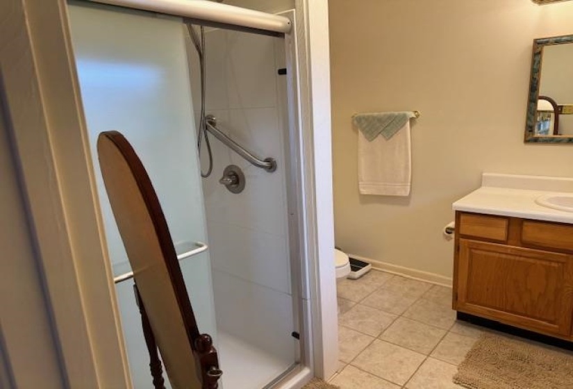 Full bathroom with vanity, light tile patterned floors, and a shower stall