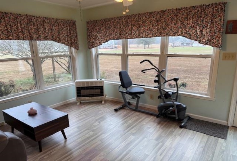 Workout room featuring heating unit and wood finished floors
