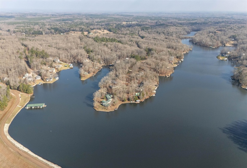 Aerial view of property's location with a heavily wooded area and a nearby body of water