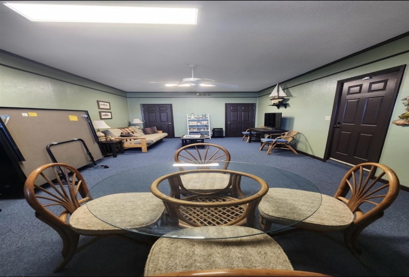 Carpeted dining room with ceiling fan and ornamental molding
