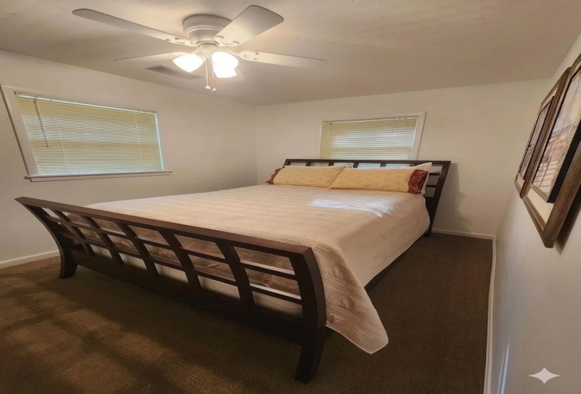 Bedroom featuring a ceiling fan and dark colored carpet