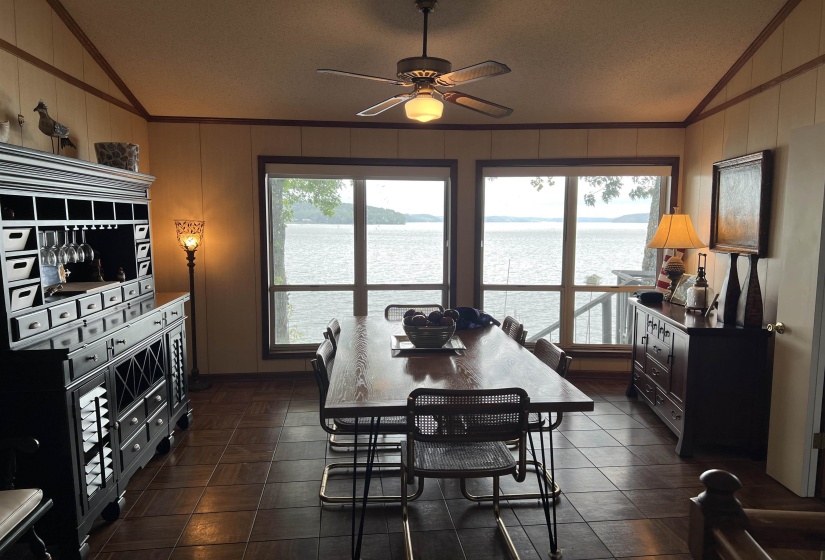 Dining space featuring lofted ceiling, crown molding, a water view, a ceiling fan, and plenty of natural light