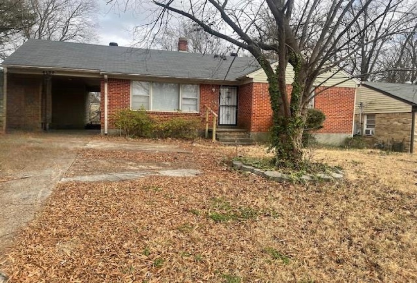 Single story home with brick siding, a chimney, and a carport