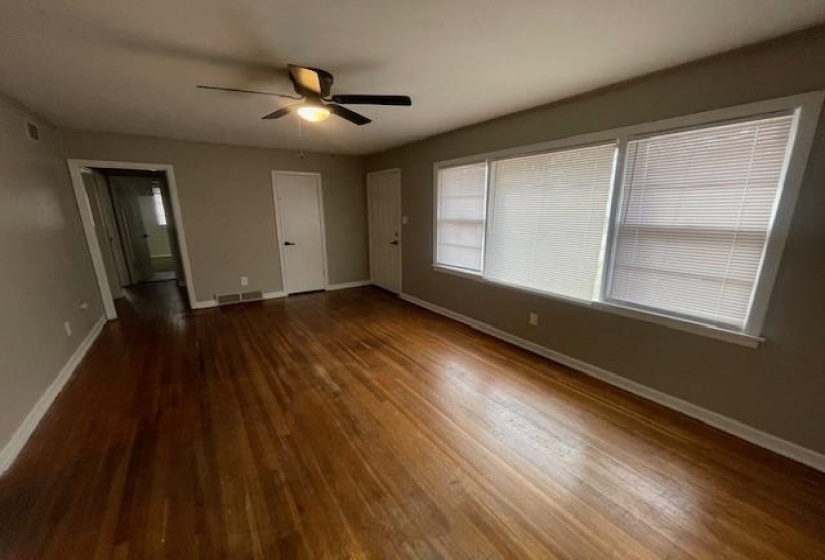 Unfurnished bedroom featuring dark wood-style floors, a ceiling fan, and connected bathroom