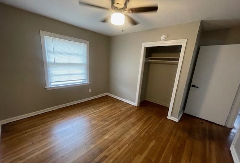 Unfurnished bedroom featuring dark wood finished floors, a ceiling fan, and a closet