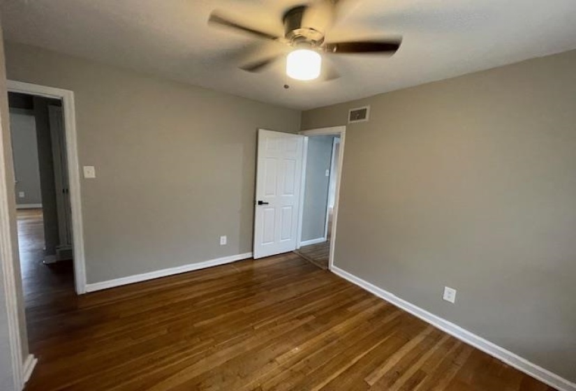 Unfurnished room featuring dark wood finished floors and a ceiling fan