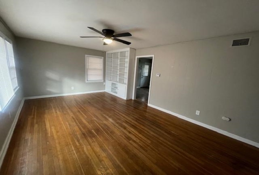 Spare room with dark wood-style floors and a ceiling fan
