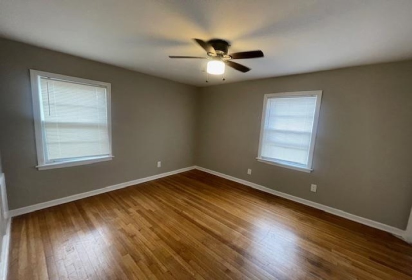 Unfurnished room featuring dark wood finished floors and a ceiling fan
