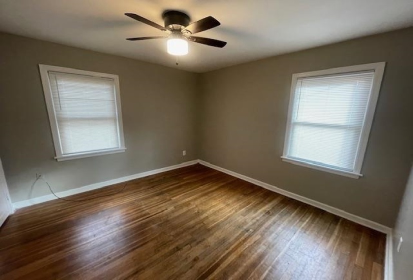 Spare room with dark wood-type flooring and ceiling fan
