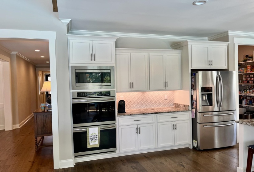 Kitchen with appliances with stainless steel finishes, decorative backsplash, recessed lighting, ornamental molding, and dark wood finished floors