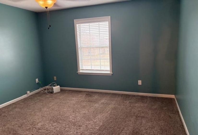 Carpeted empty room with baseboards and ceiling fan