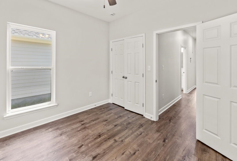 Unfurnished bedroom featuring a closet, ceiling fan, and dark wood-style flooring
