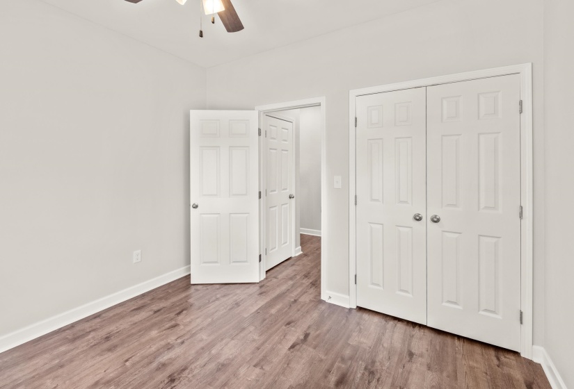 Unfurnished bedroom with wood finished floors, a closet, and ceiling fan