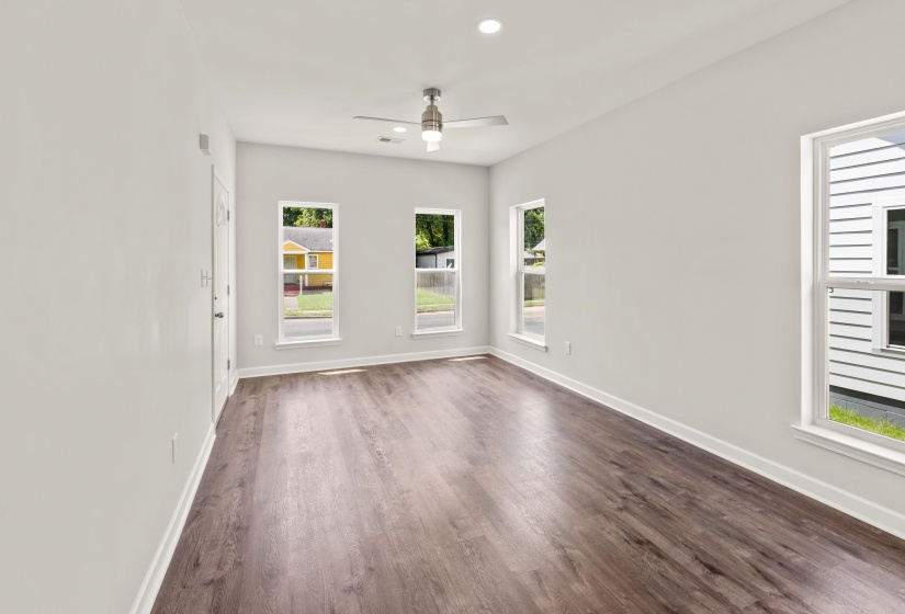 Empty room with plenty of natural light, a ceiling fan, recessed lighting, and dark wood-style flooring