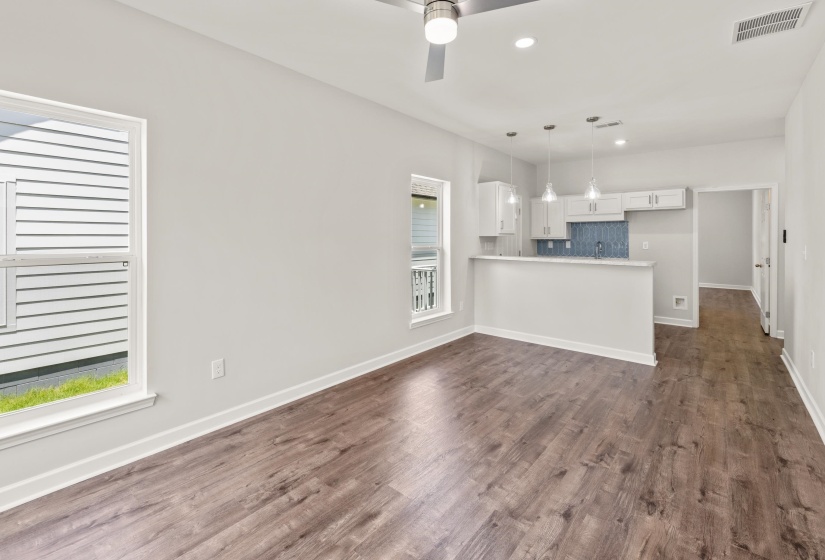 Kitchen featuring a peninsula, white cabinetry, recessed lighting, tasteful backsplash, and light countertops