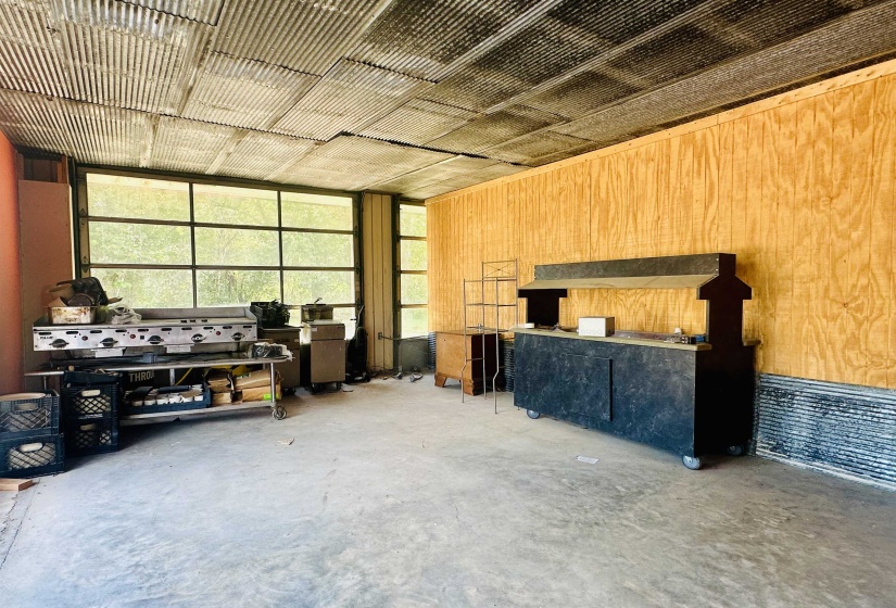 Miscellaneous room with concrete flooring and wood walls