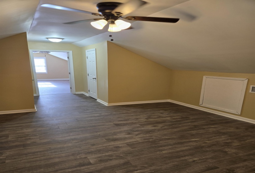 Additional living space featuring baseboards, lofted ceiling, ceiling fan, and dark wood finished floors