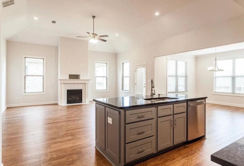 Kitchen featuring open floor plan, a kitchen island, dishwasher, light wood finished floors, and recessed lighting