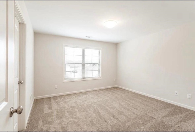 Spare room with light colored carpet and baseboards