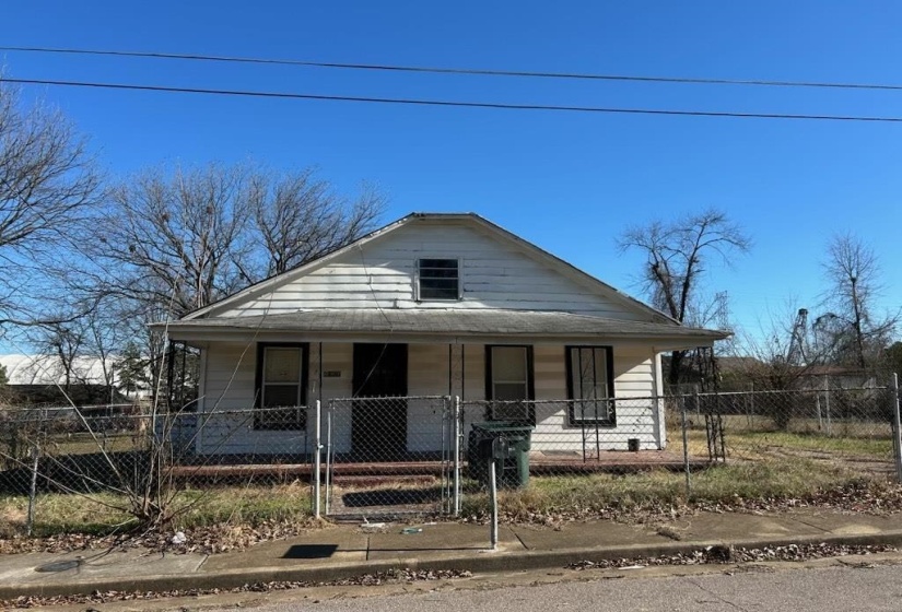 Bungalow-style house featuring covered porch, a fenced front yard, and a gate