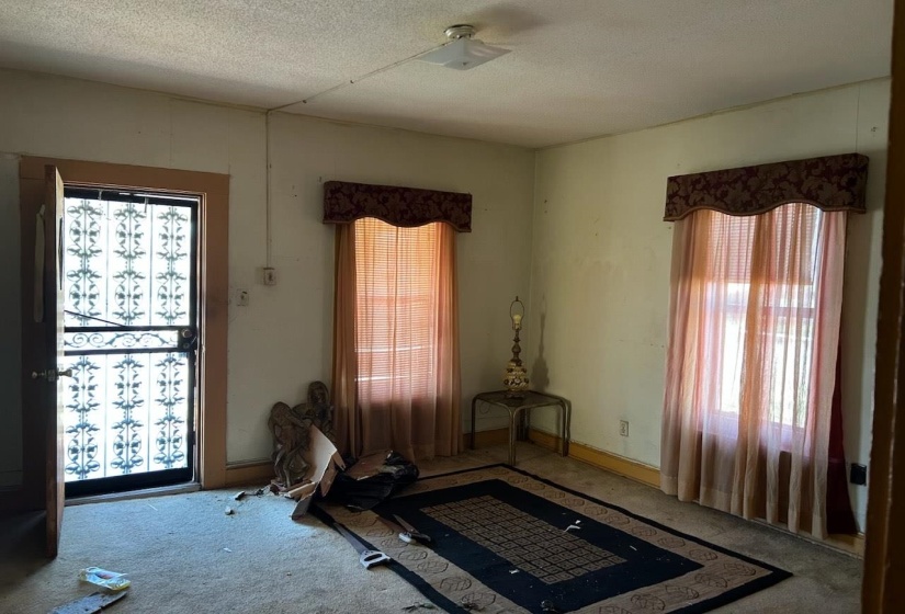 Bedroom with carpet flooring, a textured ceiling, and multiple windows