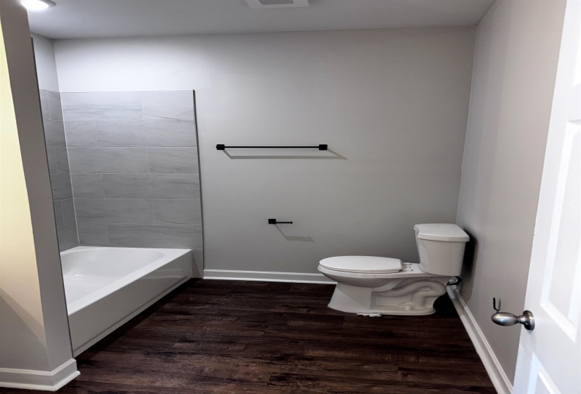 Bathroom with dark wood finished floors and toilet