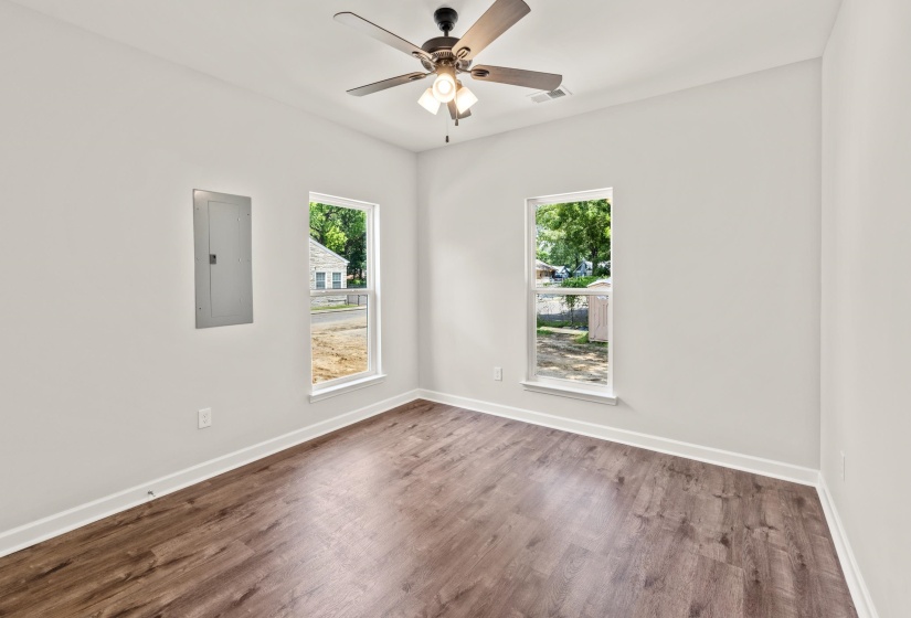 Spare room featuring electric panel, wood finished floors, and ceiling fan