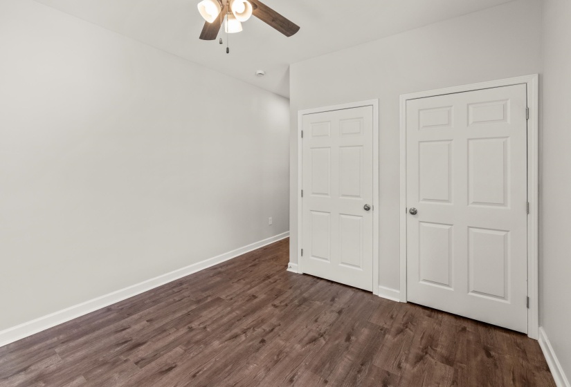 Unfurnished bedroom with dark wood-style floors and ceiling fan