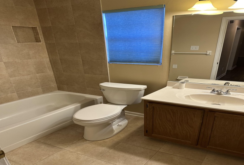 Full bathroom featuring tile patterned floors, vanity, toilet, and tiled shower / bath