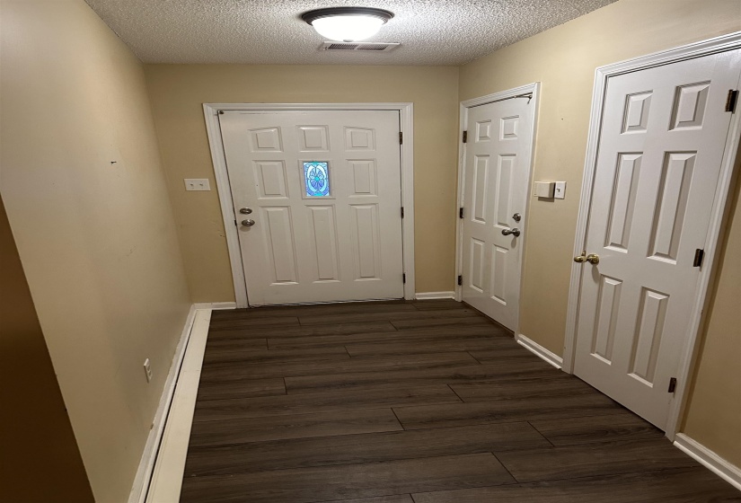Doorway featuring dark hardwood / wood-style flooring and a textured ceiling